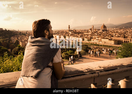 Ein junger Mann bewundert die kultige Aussicht auf die Dächer und die basiliken von Florenz vom Piazzale Michelangelo Stockfoto