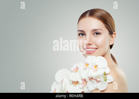 Schöne junge Frau mit weisser Orchidee auf banner Hintergrund mit kopieren. Spa Beauty, Kosmetik, Hautpflege und Wellness Konzept Stockfoto