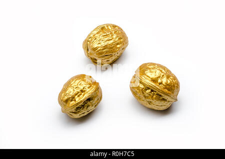 Drei goldene Walnüsse auf einem weißen Hintergrund, isoliert Stockfoto