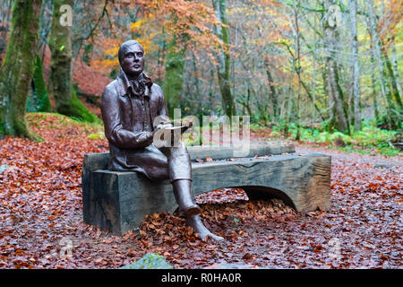 Statue des Dichters Robert Burns sitzt auf der Bank im Herbst am Birks O'Aberfeldy Scenic Area in Aberfeldy, Perthshire, Schottland, Großbritannien Stockfoto