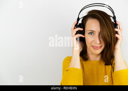 Schöne Frauen Hören mit Kopfhörern auf einem weißen Hintergrund. Stockfoto