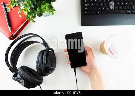 Kopfhörer und Office Tools auf einem weißen Hintergrund. E-Learning - Konzept. Stockfoto