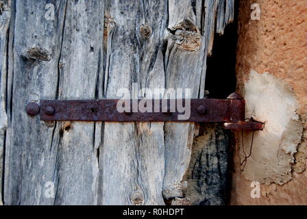 Alte Tür mit rostige Schraube, verrostet, oxidiert Scharnier, altem Holz. Stockfoto