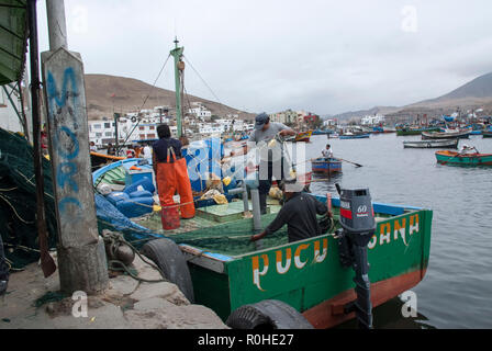 Pucusana, Peru - 17. Juni 2017: peruanische Fischer in einen Tintenfisch in Pucusana Pier in einem bewölkten Morgen stall in touristische Stadt Pucusana in der Nähe von Lima. Stockfoto