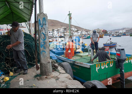 Pucusana, Peru - 17. Juni 2017: peruanische Fischer in einen Tintenfisch in Pucusana Pier in einem bewölkten Morgen stall in touristische Stadt Pucusana in der Nähe von Lima. Stockfoto