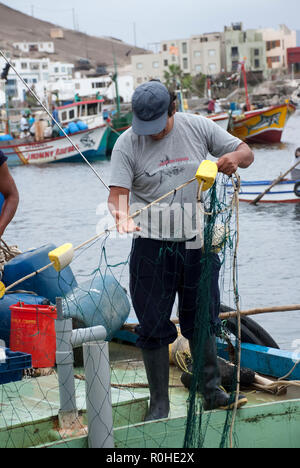 Pucusana, Peru - 17. Juni 2017: peruanische Fischer in einen Tintenfisch in Pucusana Pier in einem bewölkten Morgen stall in touristische Stadt Pucusana in der Nähe von Lima. Stockfoto