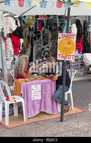 Ein tarot Card Reader und Ihrem Kunden am Carmel-markt in Tel Aviv, Israel. Ihr Zeichen ist in drei Sprachen. Stockfoto