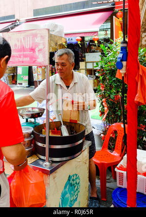 Street Hersteller rösten und Verkauf von heissen Kastanien auf Waterloo Street außerhalb der Tempel in Singapur, Sept. 2018 Stockfoto