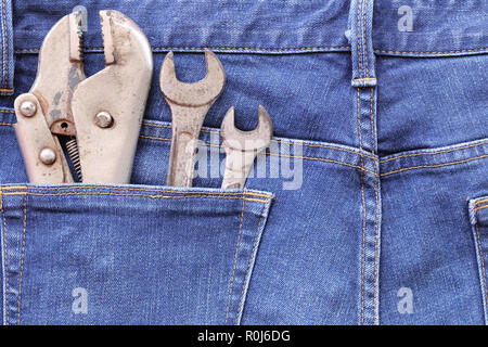 Blue Jeans der Gesäßtasche und haben alte Schraubenschlüssel mit Rost für Design in ihrem Labor Day Konzept. Stockfoto