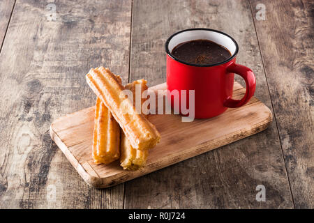 Heiße Schokolade mit churros auf hölzernen Tisch. Stockfoto