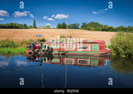 Boot an einem sonnigen Tag, mit den Bäumen und einem Feld hinter auf Grand Union Canal, in der Nähe der Black Jack's Lock, Großbritannien Stockfoto