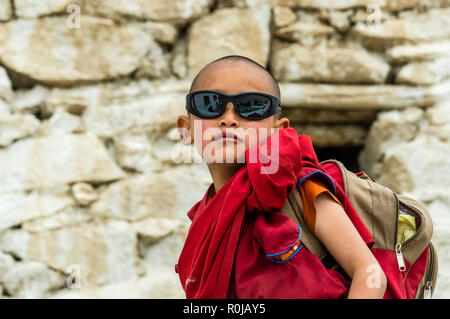 Portrait einer jungen Rot gekleidet Mönch von Thiksey Gompa, eines der wichtigsten Klöster in Ladakh, tragen Sonnenbrillen Stockfoto
