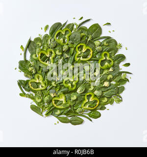 Verschiedene grünes Gemüse Brokkoli, Spinat, Rosenkohl, Spargel, Minze, Gurke und Paprika Schichten auf einem grauen Hintergrund mit Platz für Text. Gesunde Ernährung Konzept. Flach Stockfoto