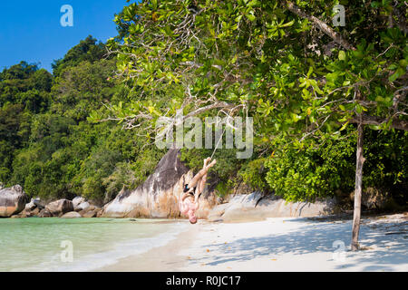 Jungen Touristen entspannen auf einfaches Schwingen auf geheimen Strand auf Pangkor Island in Malaysia. Schöne Marine und Hafen in Südostasien. Stockfoto