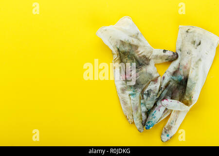Dirty Gummihandschuhe in bunten Punkte auf gelbem Hintergrund Stockfoto