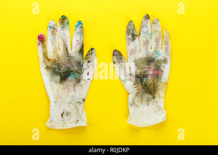 Dirty Gummihandschuhe in bunten Punkte auf gelbem Hintergrund Stockfoto