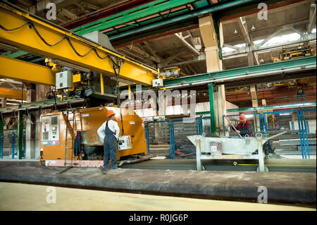 In Tjumen, Russland - 13. August 2013: Block machen Abteilung Bau Material factory ZHBI-5. Arbeitnehmer, bedienen Sie die Maschine zum Füllen von konkreten Plat Stockfoto