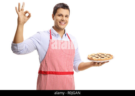 Junger Mann mit einer Torte und deutete mit der Hand auf weißem Hintergrund Stockfoto