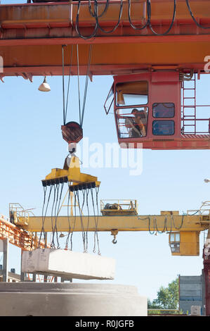 In Tjumen, Russland - 13. August 2013: Fertigwarenlager auf konkrete Ware Werk Nr. 5. Der Kranführer arbeitet im Freien Stockfoto