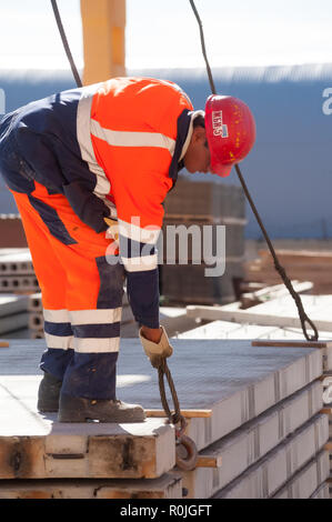 In Tjumen, Russland - 13. August 2013: Fertigwarenlager auf konkrete Ware Werk Nr. 5. Slinger akzeptiert Platten an Kranführer Stockfoto