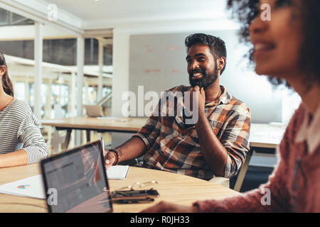 Kollegen in einem Meeting, in dem Geschäftspläne und Ideen diskutiert werden. Geschäftsmann sitzt mit weiblichen Kollegen im Konferenzraum im Büro. Stockfoto