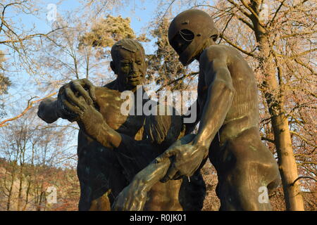 Timeline der aufgehenden Sonne im Winter Sonnenuntergang Himmel aus gesehen hinter dem Bronze Skulptur auf dem Soldatenfriedhof reimsbach an der Saar, Deutschland. Stockfoto