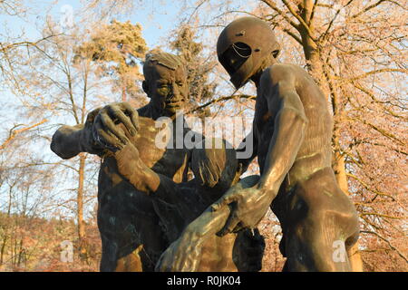 Timeline der aufgehenden Sonne im Winter Sonnenuntergang Himmel aus gesehen hinter dem Bronze Skulptur auf dem Soldatenfriedhof reimsbach an der Saar, Deutschland. Stockfoto