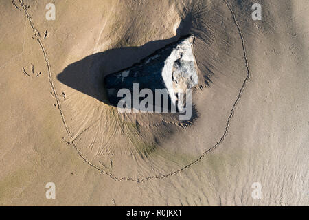 Spuren um einen Stein der ein kleines Tier in den Sand. Stockfoto