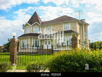 Neues, modernes Haus mit einem geschmiedeten Zaun umgeben. Closeup. Stockfoto