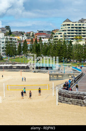 Vier Personen spielen Beachvolleyball am Coogee Beach Sydney NSW Australien. Stockfoto