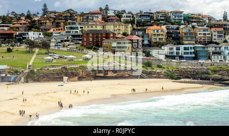 Bondi, coogee an der Küste zu Fuß und Menschen zu Fuß auf den sand Bronte Beach und Wohnungen auf Sandstein Felsen über dem Pazifischen Ozean Sydney, NSW, Australien.
