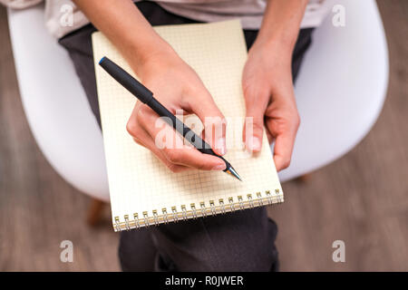 Woman's Hand schreiben auf ein leeres Notebook. Stockfoto