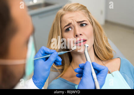 7/8 shot der Zahnarzt die Zähne von verängstigten Frau client Stockfoto