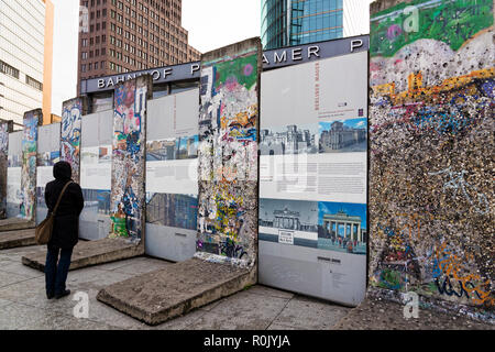 Eine Frau besucht eine Bildergalerie zwischen einige Stücke der Berliner Mauer am Potsdamer Platz am 15. April 2017 in Berlin, Deutschland Stockfoto