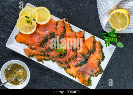 Gefarmte - Nordic Teller dünn geschnittener roher Lachs in Salz, Zucker und Dill geheilt und mit Dill und Senfsauce - Ansicht von oben begleitet Stockfoto