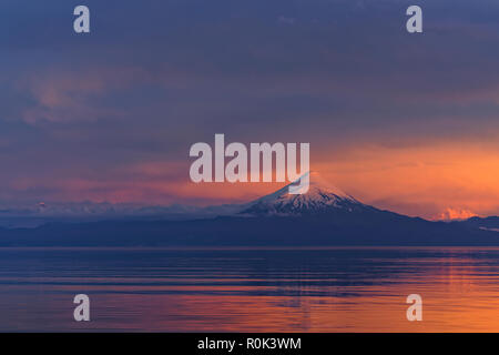 Sonnenuntergang im Süden Chiles, mit Blick auf den Vulkan Osorno und über den Llanquihue See, seine Silhouette spiegelt Stockfoto