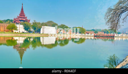 Die hohen roten hölzernen Turm und Brücke aus Stein Willkommen Besucher der Königlichen Palast in Mandalay, Myanmar Stockfoto