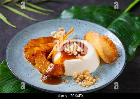 Panna cotta mit karamellisierter Ananas und Kokosnuss Keks Stockfoto