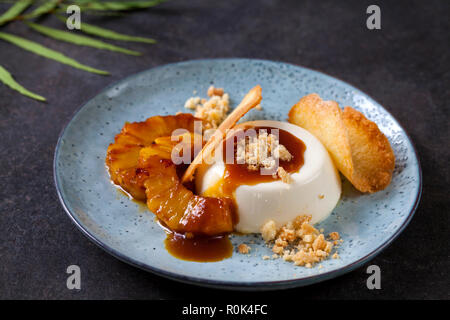 Panna cotta mit karamellisierter Ananas und Kokosnuss Keks Stockfoto
