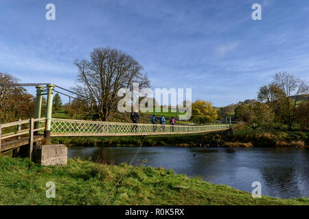 Wanderer auf dem Dales Weg überqueren der Hebden Hängebrücke über den Fluss Wharfe Stockfoto