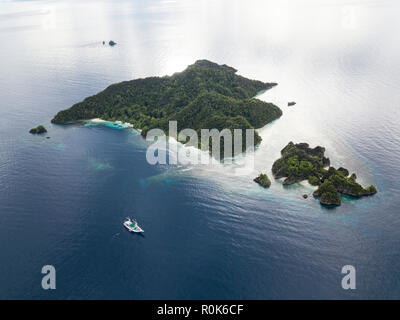 Einen Pinisi Schoner sitzt vor Anker in einer abgelegenen Gegend von Raja Ampat im Osten Indonesiens. Stockfoto