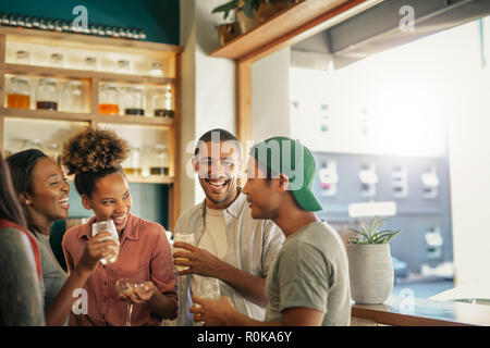 Diverse junge Freunde sprechen und zusammen trinken in einer Bar Stockfoto