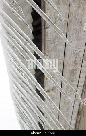 Geschmolzener Schnee und großen Eiszapfen hängen von dem Dach des Hauses. Selektive konzentrieren. Stockfoto