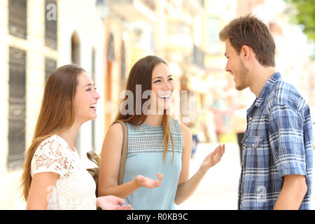 Drei smiley Freunde sprechen und lachen auf der Straße Stockfoto