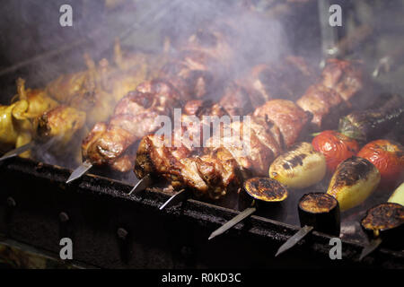 Schweinefleisch, Wachteln und Gemüse Grillen am Spieß braten auf einem Grill Brazier Stockfoto