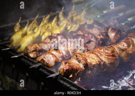 Schweinefleisch und Wachteln Grill am Spieß braten auf einem Grill Brazier Stockfoto