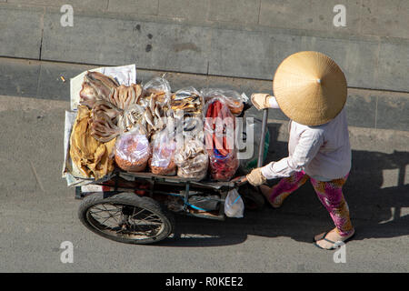 Vietnamesische Frau treibt einen Wagen voller getrocknetem Fisch und Meeresfrüchte, Saigon Stadt. Stockfoto