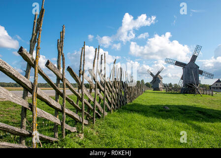 Holzzaun und Windmühlen gegen den blauen Himmel in etnografisches Museum in Angla auf der Insel Saaremaa in Estland Stockfoto