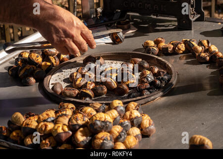 Gebackene Kastanien auf dem Grill für den Verkauf auf der Straße Stockfoto