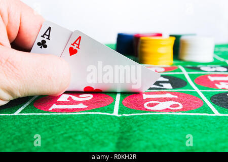 Zwei Asse mit Chips am grünen Tisch. Spielen und Gewinnen ein abstraktes Konzept. Mann Hand. Stockfoto